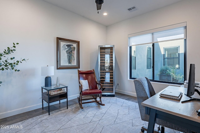 office featuring ceiling fan, a wealth of natural light, and light wood-type flooring