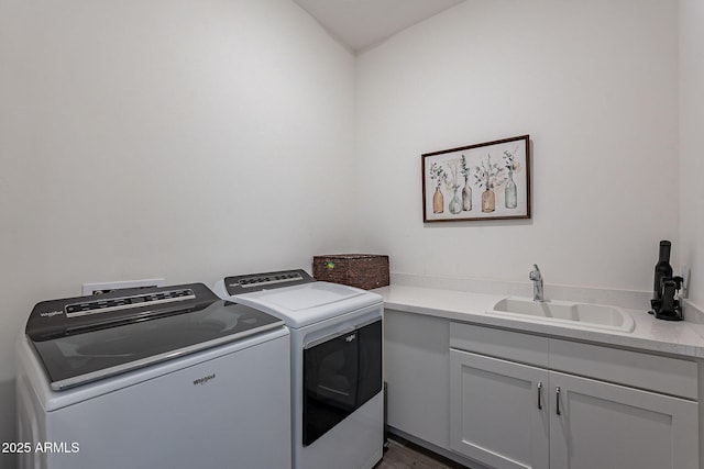 laundry area featuring cabinets, sink, and washing machine and dryer