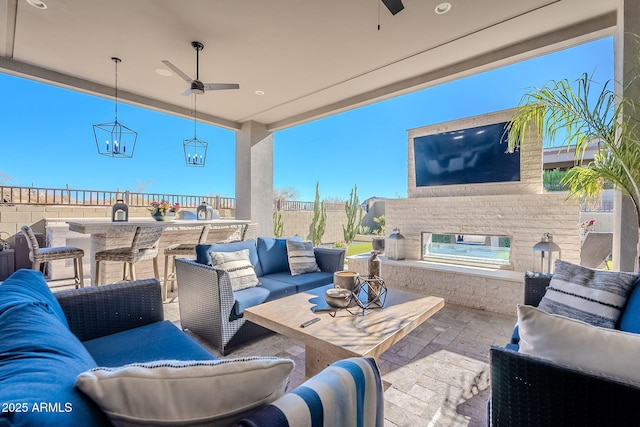 view of patio with an outdoor living space with a fireplace, an outdoor bar, and ceiling fan