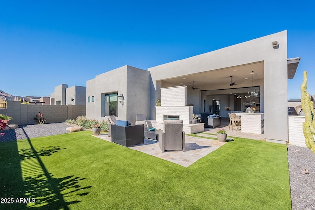 back of property with a patio, a bar, an outdoor living space with a fireplace, a lawn, and ceiling fan