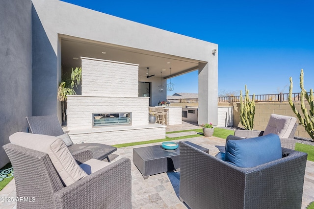 view of patio / terrace featuring ceiling fan, an outdoor living space with a fireplace, and area for grilling