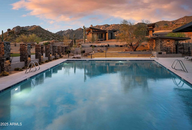 pool at dusk with a mountain view and a patio