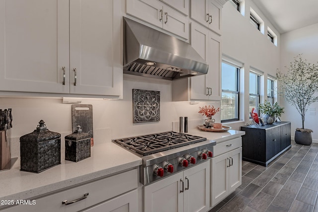 kitchen with white cabinets, ventilation hood, light stone countertops, and stainless steel gas cooktop