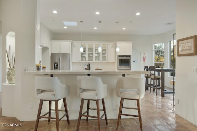 kitchen featuring appliances with stainless steel finishes, a kitchen breakfast bar, kitchen peninsula, and white cabinets