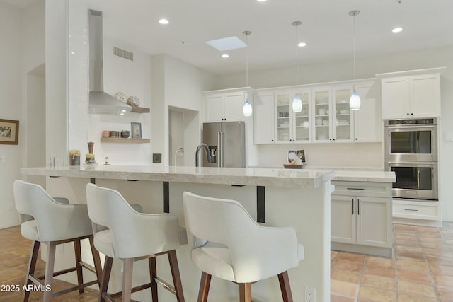 kitchen featuring hanging light fixtures, a breakfast bar, white cabinets, and appliances with stainless steel finishes