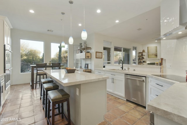 kitchen featuring a kitchen island, pendant lighting, white cabinets, exhaust hood, and stainless steel appliances