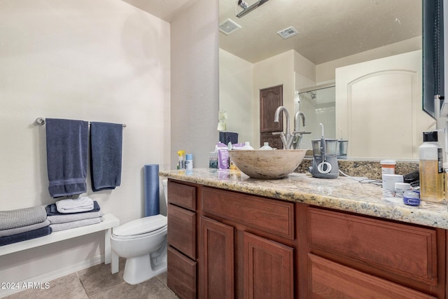 bathroom with tile patterned floors, vanity, toilet, and an enclosed shower