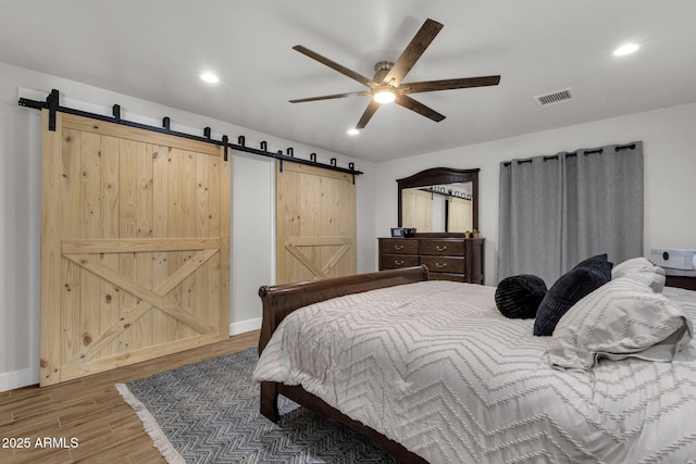 5112 E Cholla St, Scottsdale, AZ 85254 - bedroom featuring a barn door, wood finished floors, recessed lighting, a ceiling fan, and baseboards