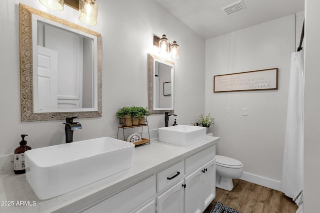 5112 E Cholla St, Scottsdale, AZ 85254 - bathroom with wood finished floors, toilet, double vanity, and baseboards