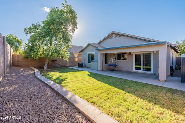 rear view of house featuring a yard, a patio, and central AC