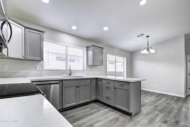 kitchen featuring gray cabinets, sink, stainless steel dishwasher, and kitchen peninsula