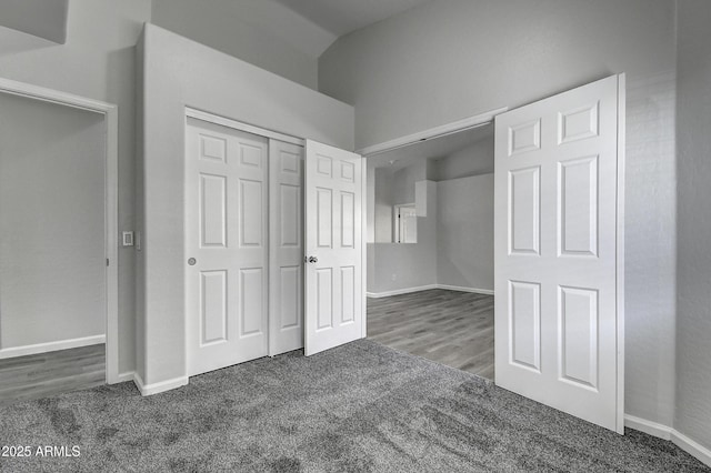 unfurnished bedroom featuring dark carpet and a closet