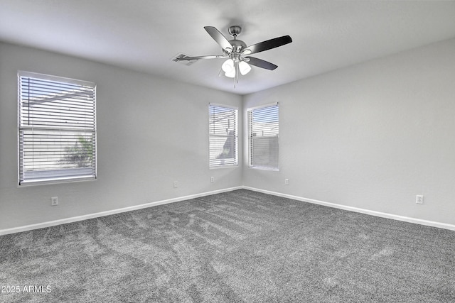 empty room with ceiling fan and dark carpet