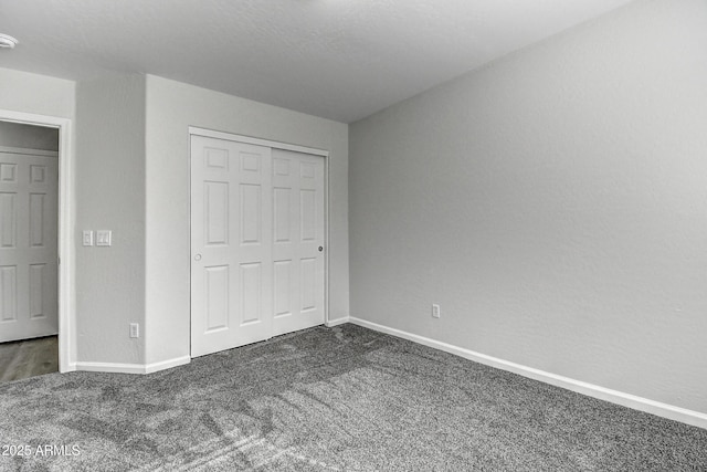 unfurnished bedroom featuring dark colored carpet and a closet