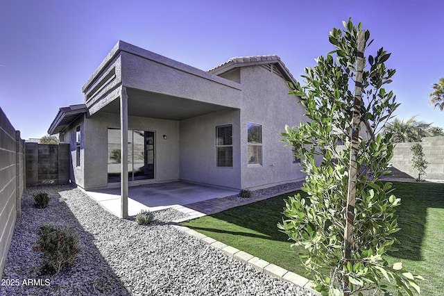 rear view of property with a lawn and a patio