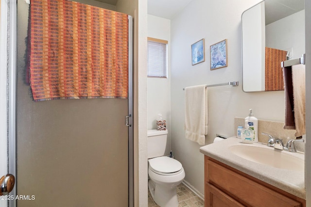 bathroom featuring vanity, an enclosed shower, and toilet