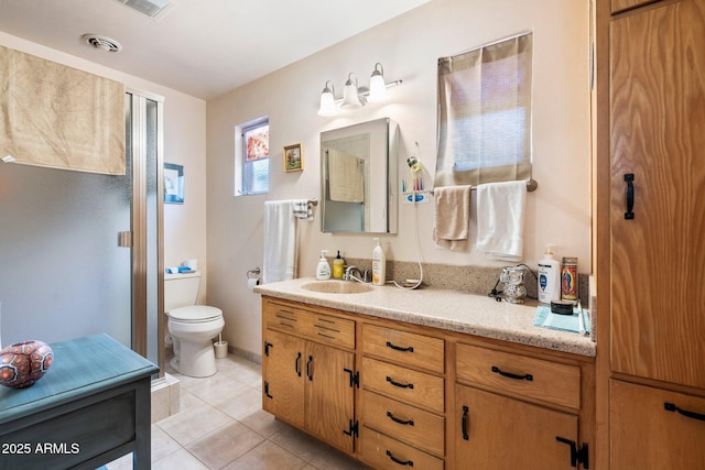 bathroom featuring vanity, tile patterned floors, and toilet