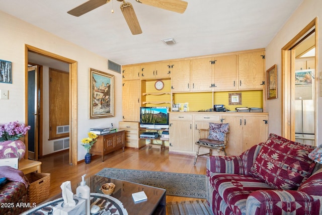 living room with ceiling fan and light wood-type flooring