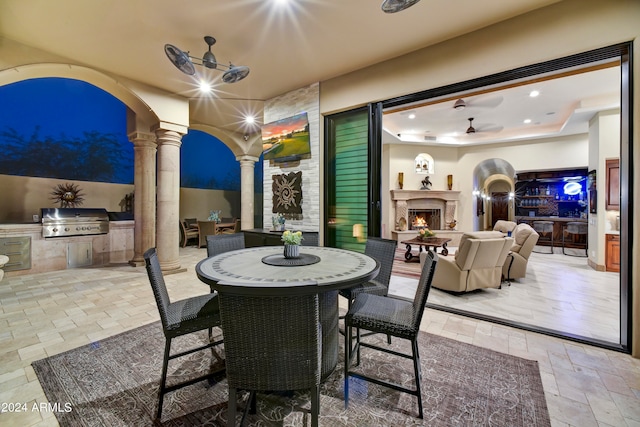 view of patio / terrace featuring an outdoor kitchen, exterior fireplace, and a grill