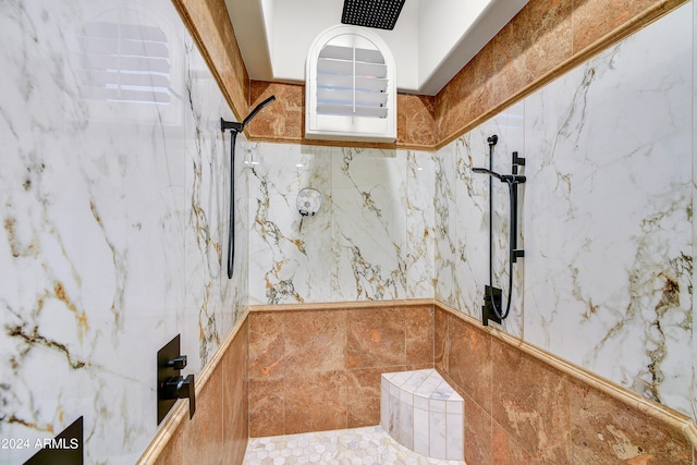 interior space with tiled shower and tile walls