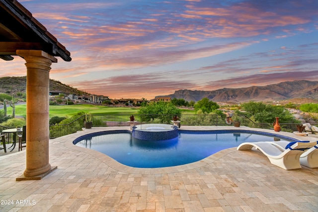 pool at dusk with a mountain view and a patio area