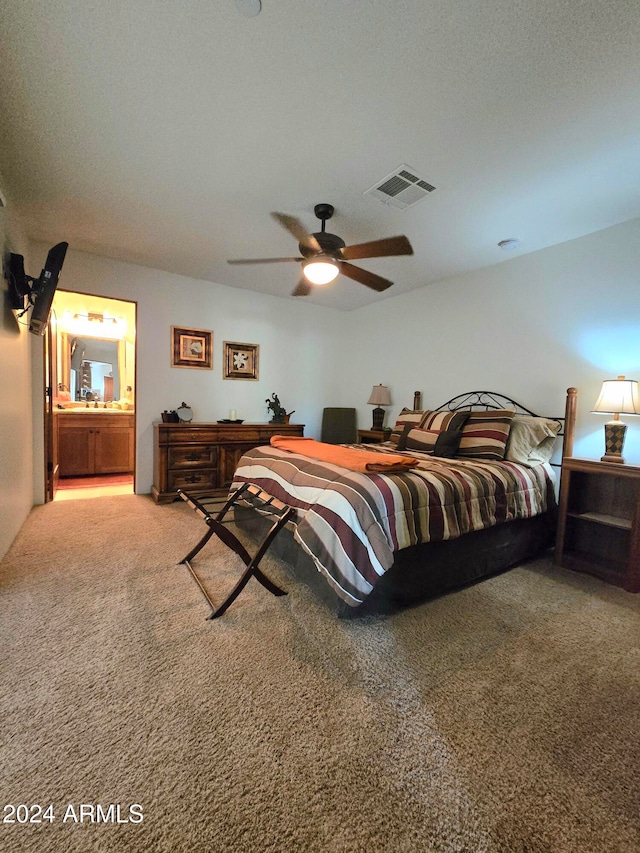 bedroom with carpet, connected bathroom, and ceiling fan