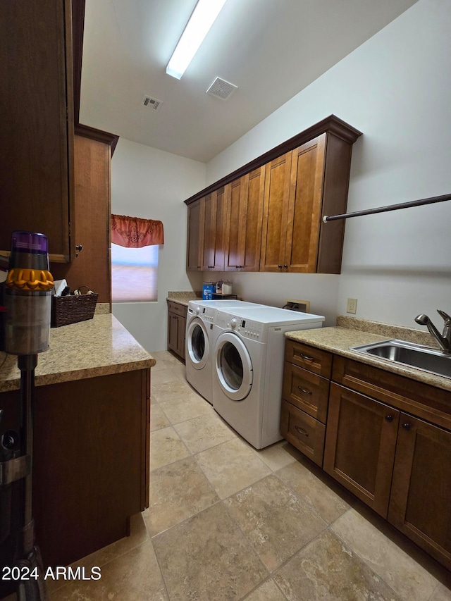 laundry room featuring cabinets, separate washer and dryer, and sink