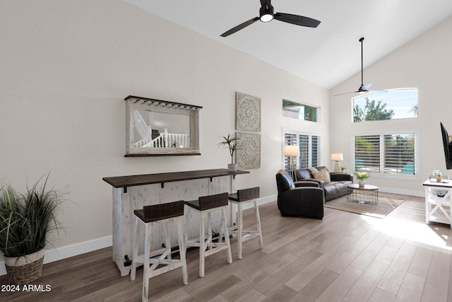 living room featuring hardwood / wood-style floors, ceiling fan, and high vaulted ceiling