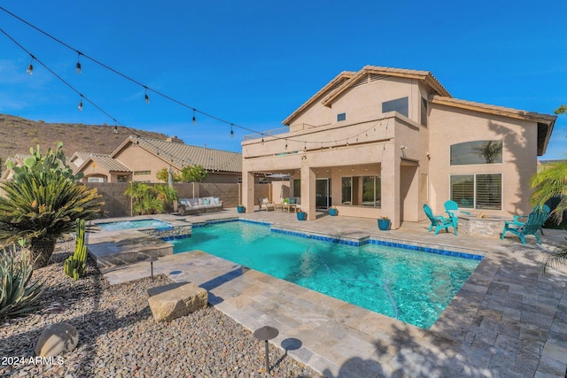 view of swimming pool with an outdoor living space, an in ground hot tub, and a patio