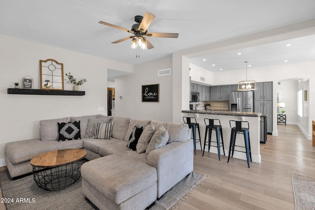 living room featuring light wood-type flooring and ceiling fan