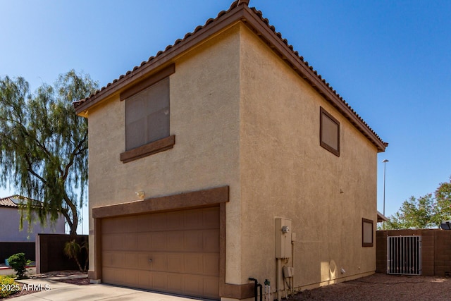 3235 S Bowman Rd, Apache Junction, AZ 85119 - view of home's exterior with a tiled roof, stucco siding, and an attached garage