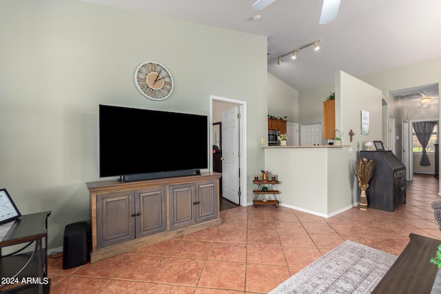 living area with light tile patterned floors, ceiling fan, lofted ceiling, and baseboards