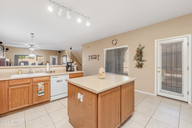 kitchen with white dishwasher, ceiling fan, sink, a center island, and light tile patterned flooring