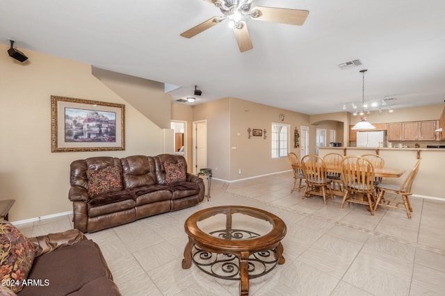 living room with light tile patterned floors and ceiling fan with notable chandelier