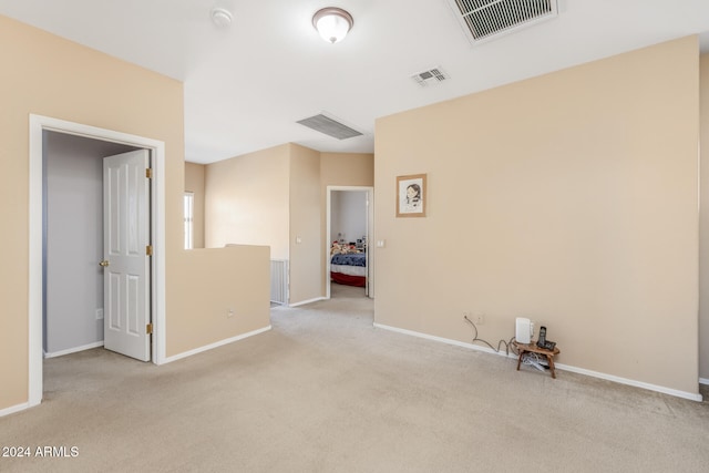 unfurnished room featuring light carpet