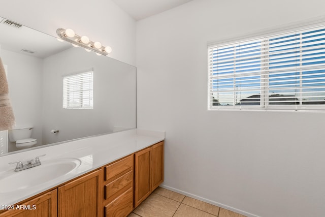 bathroom with toilet, vanity, and tile patterned floors