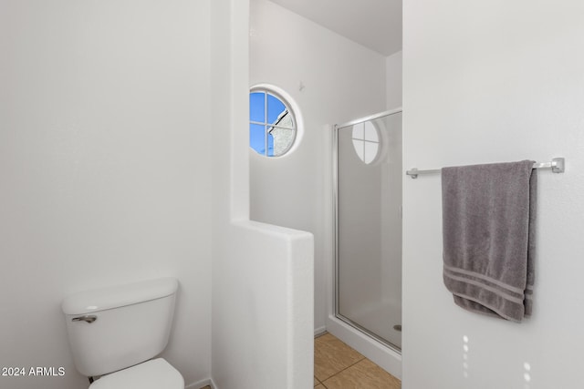 bathroom featuring tile patterned flooring, toilet, and an enclosed shower