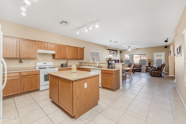 kitchen featuring white appliances, ceiling fan, light tile patterned floors, a kitchen island, and hanging light fixtures