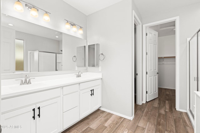 bathroom featuring walk in shower, wood-type flooring, and vanity