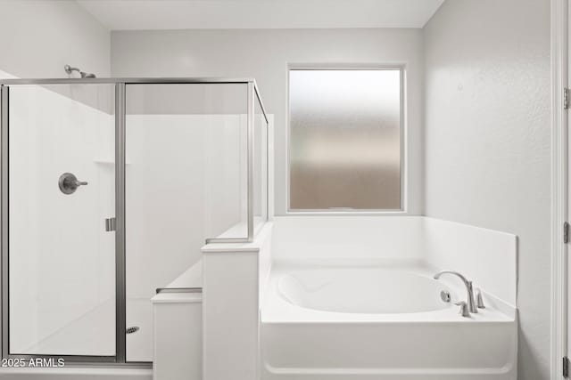 bathroom featuring shower with separate bathtub