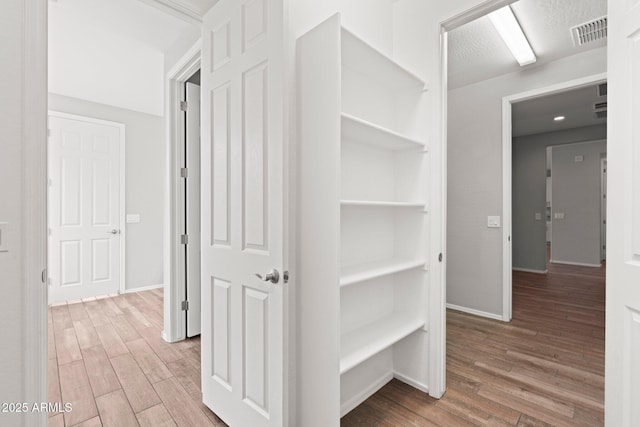 corridor with wood-type flooring