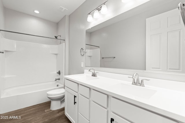 full bathroom with vanity, hardwood / wood-style flooring, bathtub / shower combination, and toilet