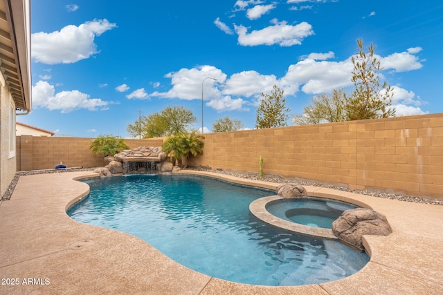 view of swimming pool featuring pool water feature and an in ground hot tub