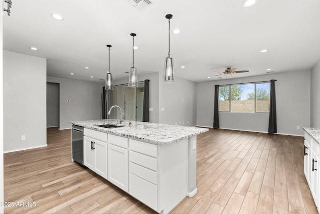 kitchen with sink, decorative light fixtures, a center island with sink, dishwasher, and white cabinets