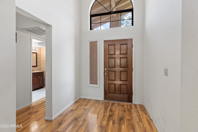 entrance foyer with light hardwood / wood-style flooring and a high ceiling