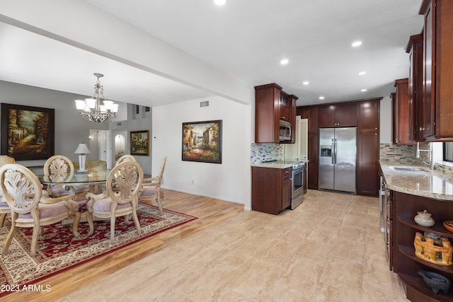 dining space featuring a chandelier, sink, and light wood-type flooring