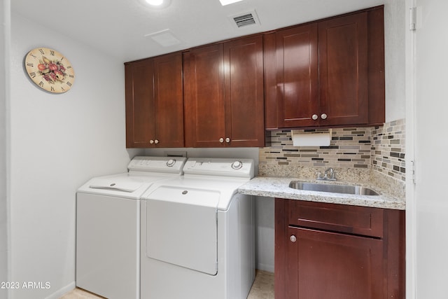 laundry area featuring cabinets, sink, light tile flooring, and washer and dryer