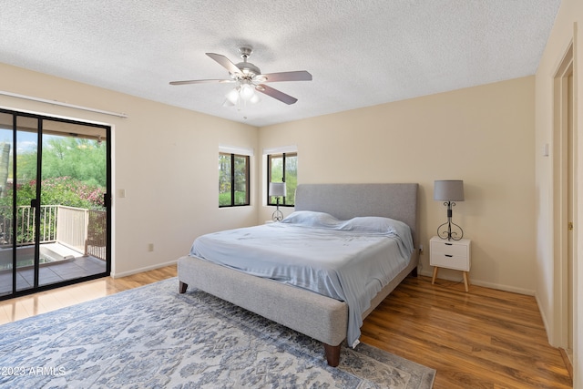 bedroom featuring light hardwood / wood-style flooring, a textured ceiling, ceiling fan, and access to exterior