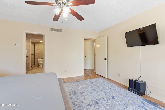 bedroom featuring a textured ceiling, ceiling fan, ensuite bathroom, and light wood-type flooring