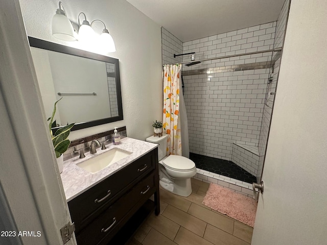 bathroom featuring tile patterned floors, vanity, toilet, and walk in shower